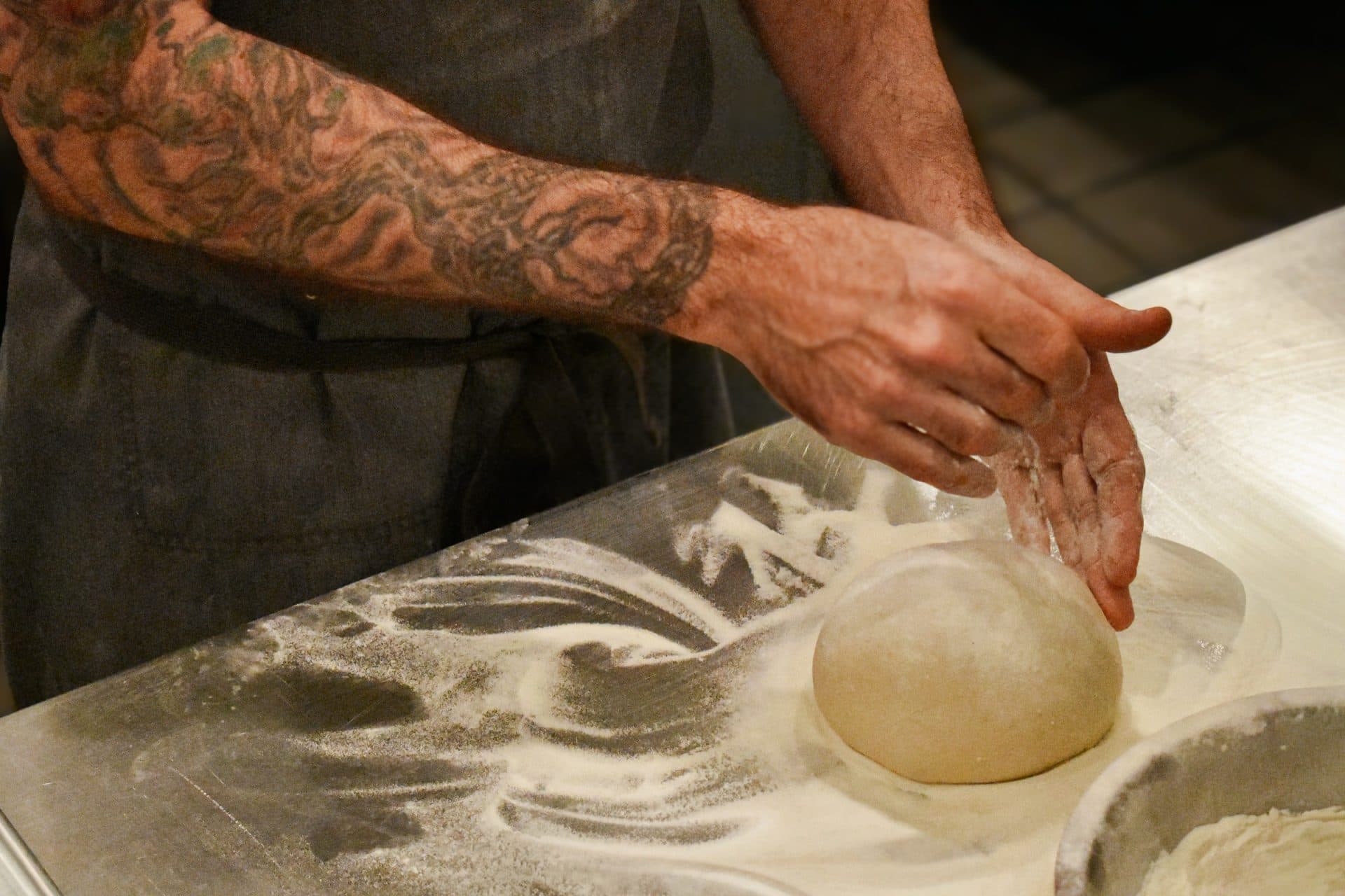 a chef prepares uncooked pizza dough